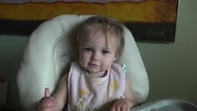 HIDDEN LAKE COLORADO-2015: Small Child Sits In High Chair While Smiling And Waving