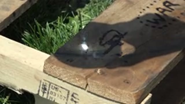 DENVER COLORADO-2015: Person Using A Glass Cup On Top Of A Wood With Sunlight To Create Fire