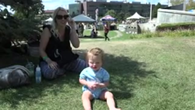 DENVER COLORADO-2015: A Smiling Blonde Mother Sits Behind Her Toddler Daughter