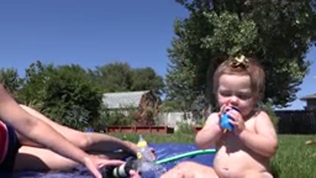 WESTMINSTER COLORADO-2015: Mother and Toddler Sunbathing Outdoors with Water