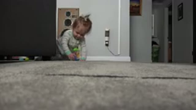 WESTMINSTER COLORADO-2015: Baby Wearing Green and White Sleeper Sits on Grey Carpet