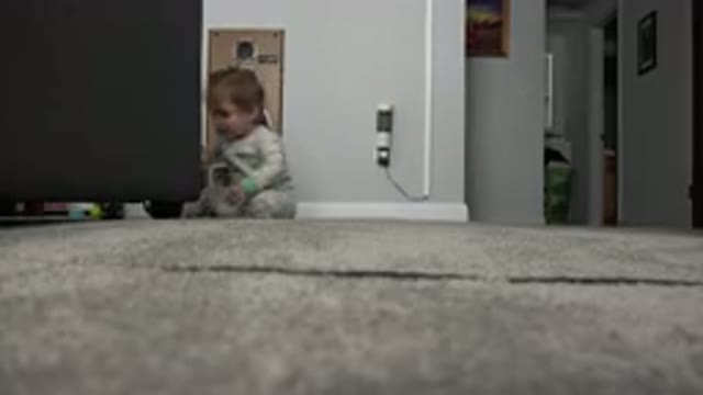 WESTMINSTER COLORADO-2015: Baby Wearing Green and White Sleeper Sits Near Large Speaker