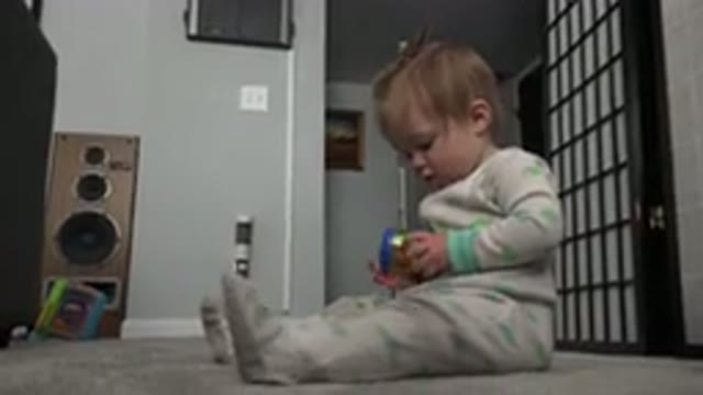 WESTMINSTER COLORADO-2015: Curious Toddler Girl Sitting on Floor Playing with Toy