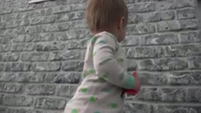 WESTMINSTER COLORADO-2015: A Child Is Next To A Big Grey Wall And Starts To Bounce
