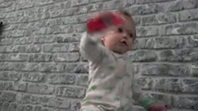 WESTMINSTER COLORADO-2015: Toddler Wearing Green And White Sleeper Plays With Objects Indoors
