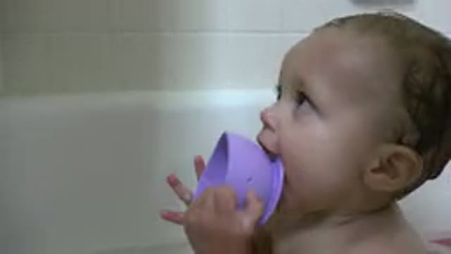 WESTMINSTER COLORADO-2015: Baby Safely Sitting in Bathtub Biting Violet Plastic Toy