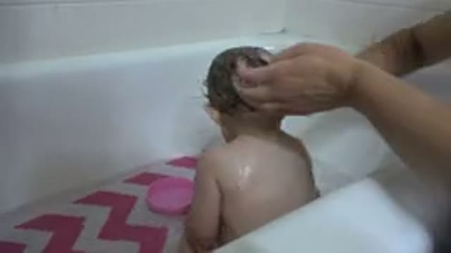 WESTMINSTER COLORADO-2015: Mother Rubbing Her Baby's Hair in a Bathtub
