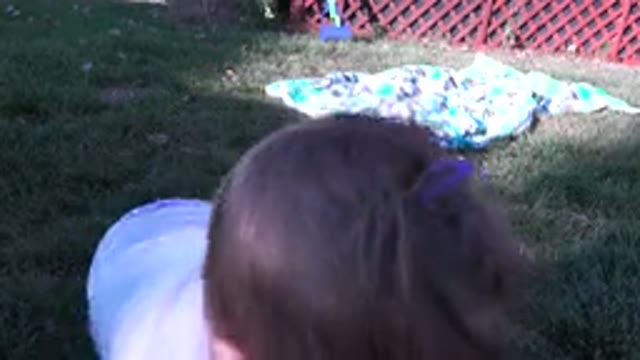 WESTMINSTER COLORADO-2015: Child Drinking On The Grass Near A Leaf Patch