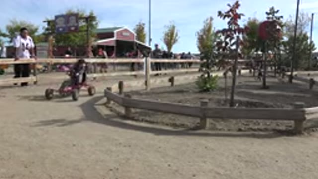 BRIGHTON COLORADO-2015: A Young Boy Riding His Four Legged Balanced Bike In A