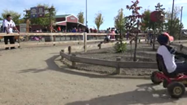 BRIGHTON COLORADO-2015: Adults Riding A Four-Legged Balanced Bike With People In