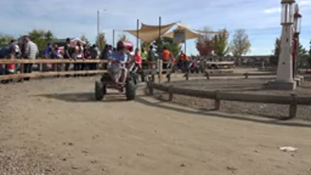 BRIGHTON COLORADO-2015: Two Adults Riding A Four Legged Bike With People