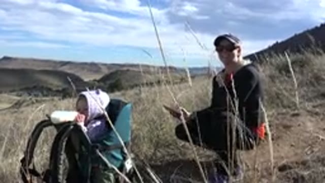 GOLDEN COLORADO-2015: Woman Wearing Black Jacket And Hat Waves At Camera On A Sunny Day