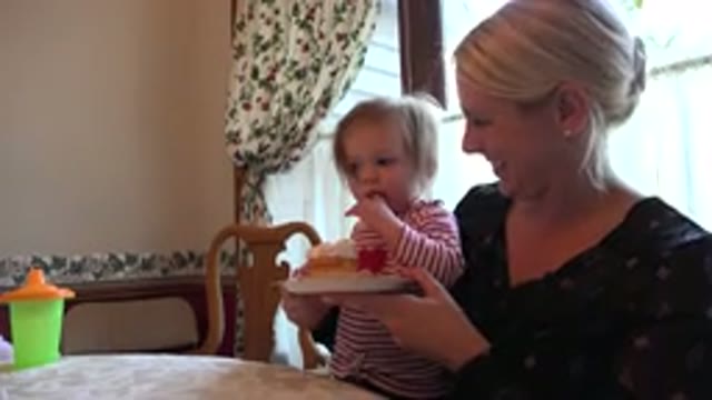 PRAIRIE GROVE ILLINOIS-2015: Small Child Tries Baked Cake While Sitting On