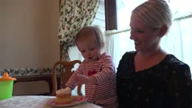 PRAIRIE GROVE ILLINOIS-2015: Toddler Wearing Red Striped Shirt Eats Cake While Standing on Woman's Lap