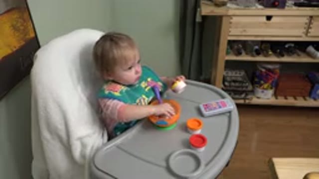 WESTMINSTER COLORADO-2015: Blonde Toddler Eats From Green Pot In High Chair
