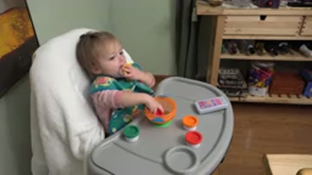 WESTMINSTER COLORADO-2015: Baby Girl Wearing Green Apron Sitting in Meal Chair