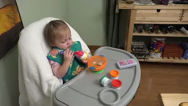 WESTMINSTER COLORADO-2015: Toddler Sits In Baby Chair And Plays With Kitchen