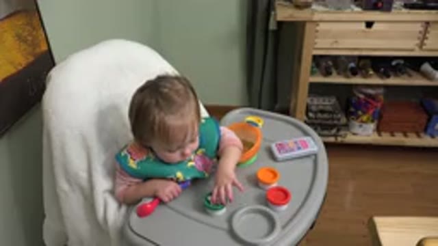WESTMINSTER COLORADO-2015: Blond Baby Playing With Toys While Sitting On Chair