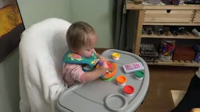 WESTMINSTER COLORADO-2015: Toddler Sitting at Table Learning to Eat with Spoon and Cup