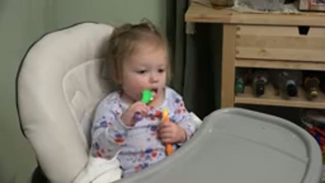 WESTMINSTER COLORADO-2015: Infant Sitting in White Highchair Eats From Green Bowl