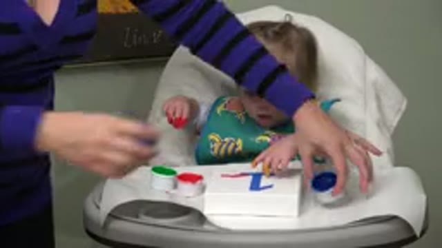 WESTMINSTER COLORADO-2015: Toddler Sitting in Highchair Sticks Fingers in White Paint