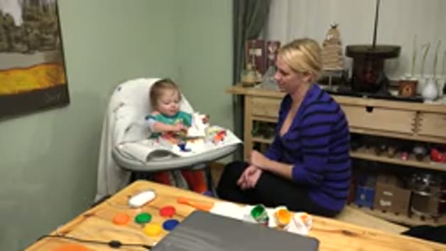 WESTMINSTER COLORADO-2015: Older Woman Sitting Next To A Baby In A High Chair During Finger Painting