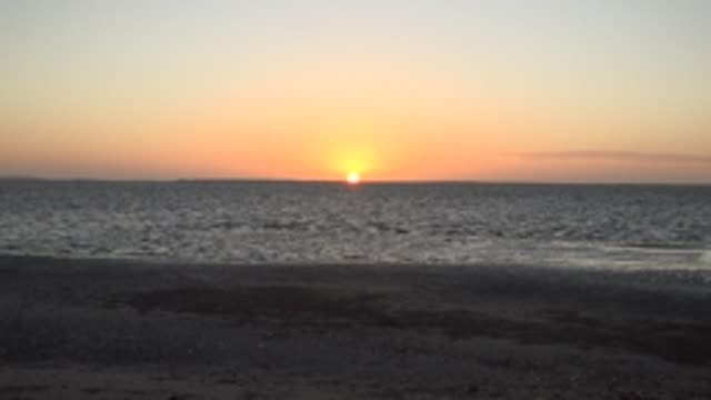 SAN CARLOS BCS MEXICO-2022: Gentle Waves Lapping a Sandy Beach at Sunset