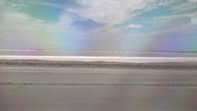 GUERRERO NEGRO BCS MEXICO-2022: Beach with Rainbow and Red Vehicle Passing