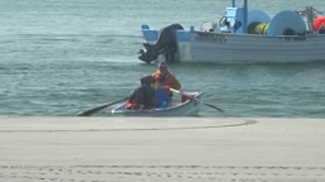 LA BOCANA BCS MEXICO-2022: Two People Rowing a Small Boat at the Water's Edge