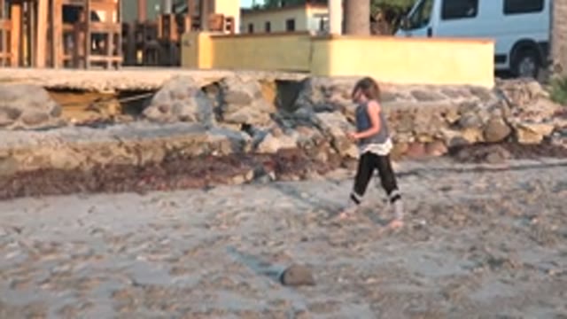 SAN CARLOS BCS MEXICO-2022: Girl Dancing on Sandy Beach near Rocks