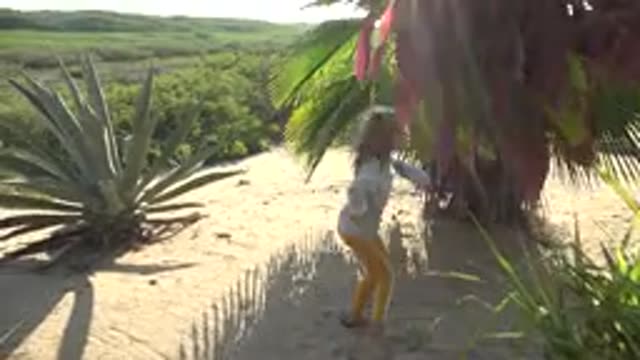 SAN CARLOS BCS MEXICO-2022: Child Walking Through Sandy Garden with Tropical Plants