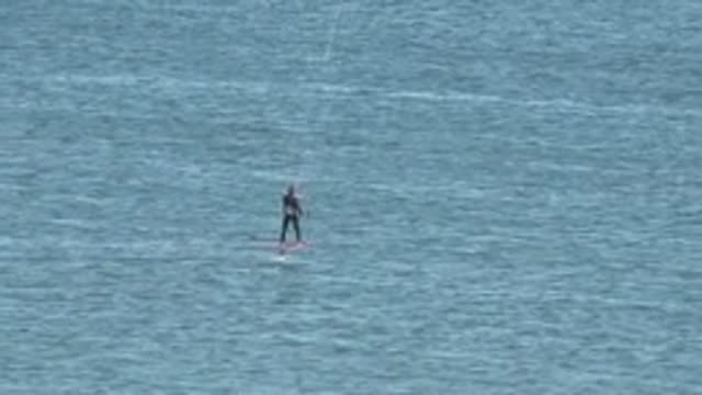 SAN JUANICO BCS MEXICO-2022: Kiteboarder Gliding Over Calm Ocean Water