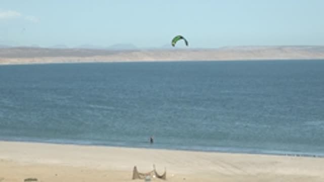 SAN JUANICO BCS MEXICO-2022: Kite Surfer Moving From Shore Into Ocean