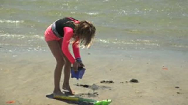 SAN CARLOS BCS MEXICO-2022: Girl Playing with Sand Bucket on Sandy Beach