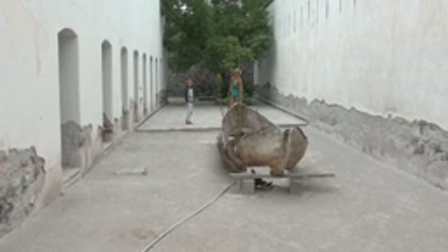 MULEGE BCS MEXICO-2022: Two People Walking Toward Camera in White-Walled Courtyard