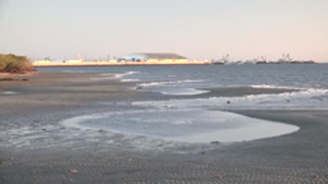 SAN CARLOS BCS MEXICO-2022: Waves Receding on Dark Sand Beach near Coastal Structure
