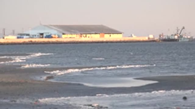 SAN CARLOS BCS MEXICO-2022: Gentle Ocean Waves at Beach Near Coastal Building