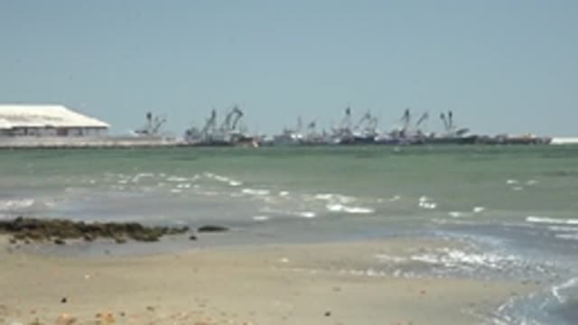 SAN CARLOS BCS MEXICO-2022: Coastal Beach with Gentle Waves and Port Cranes