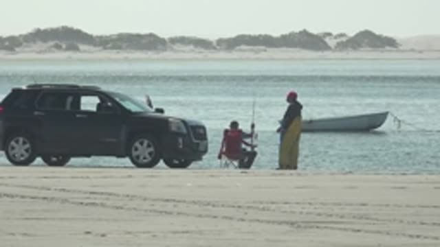 LA BOCANA BCS MEXICO-2022: Two People Fishing on the Beach with a Parked SUV