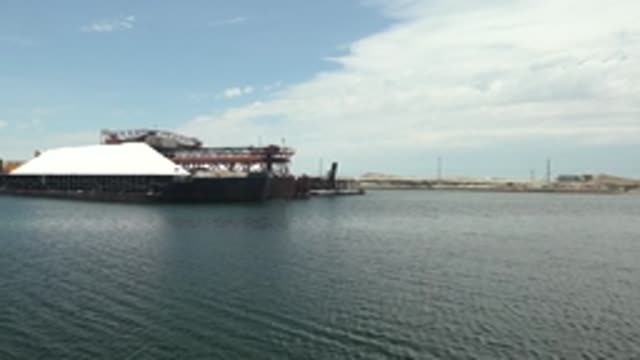 GUERRERO NEGRO BCS MEXICO-2022: Barge with White Cover and Crane Moving Into Frame