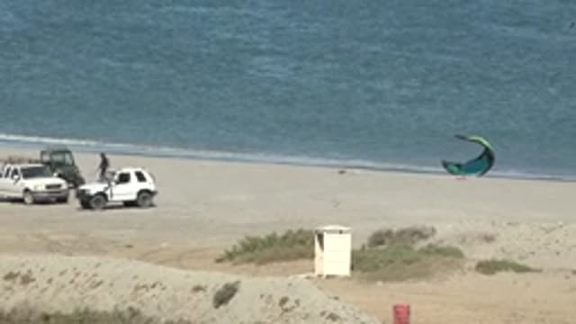 SAN JUANICO BCS MEXICO-2022: Vehicles and Kite Surfers on Sandy Beach