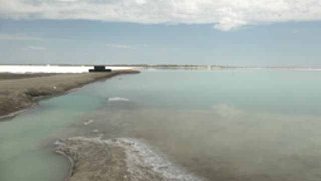 GUERRERO NEGRO BCS MEXICO-2022: Turquoise Water and Salt-Encrusted Shore with Distant Platform