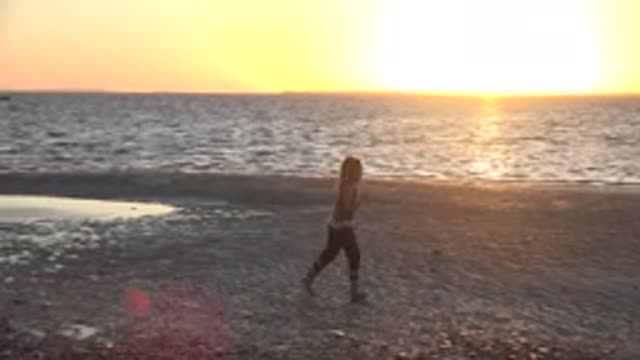 SAN CARLOS BCS MEXICO-2022: Girl Running and Jumping on a Sandy Beach at Sunset
