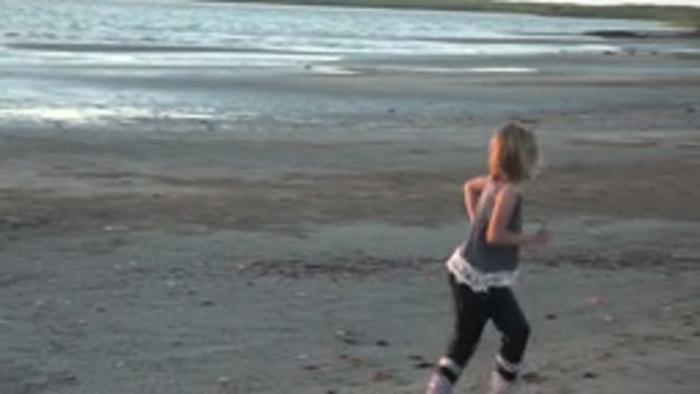 SAN CARLOS BCS MEXICO-2022: Child Running Along Sandy Beach Toward Shore