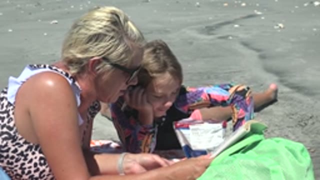 LA BOCANA BCS MEXICO-2022: Woman and Child Interacting with Book on Beach