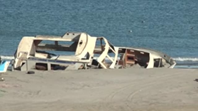 SAN JUANICO BCS MEXICO-2022: Wrecked Boat on Sandy Shore with Shifting Debris