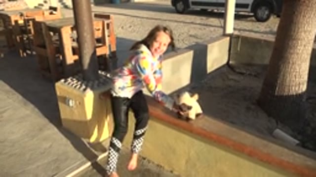 SAN CARLOS BCS MEXICO-2022: A Child Plays with a Stuffed Toy on an Outdoor Patio