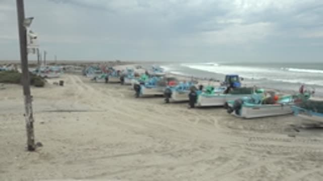 PUENTA ABREOJOS BCS MEXICO-2022: Fishing Boats on Sandy Beach with People Moving