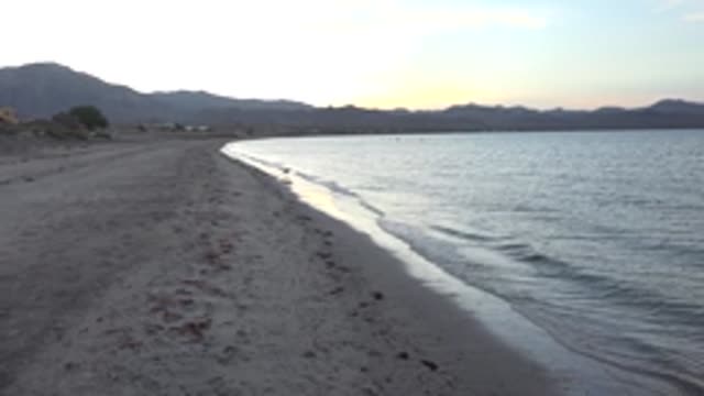 BAHIA DE LOS ANGELES BCS MEXICO-2022: Gentle Ocean Waves Lapping a Sandy Beach at Dawn