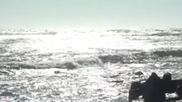 LA BOCANA BCS MEXICO-2022: Waves Crashing Against Rocky Shore Under Bright Sun